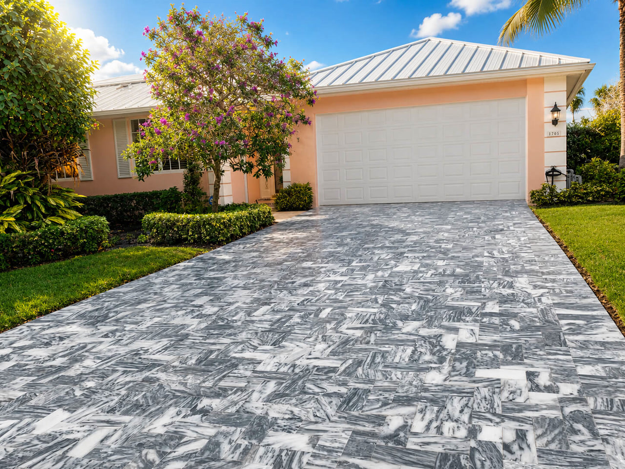 Gray veined marble driveway laid in herringbone leading to the garage of a coral home for a Gulfstream homeowner