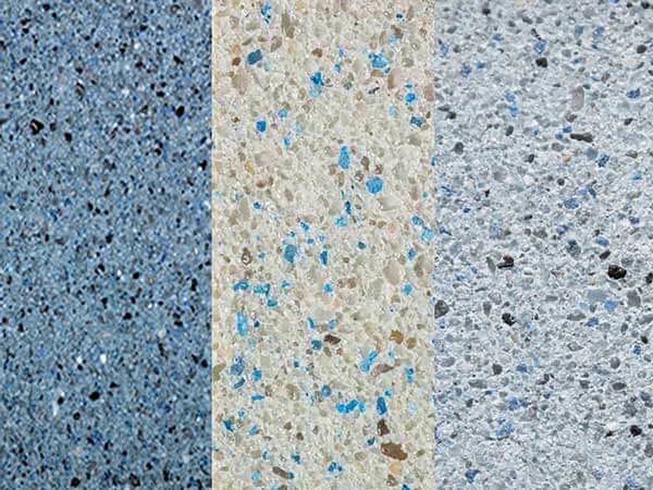 Three gem aggregate pool finish samples, from steel blue to cream and pale gray with blue glass flecks, in a Pompano Beach backyard
