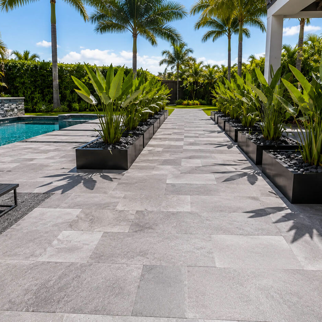 Gray paver walkway running between black planters to connect the pool deck with the rest of the backyard